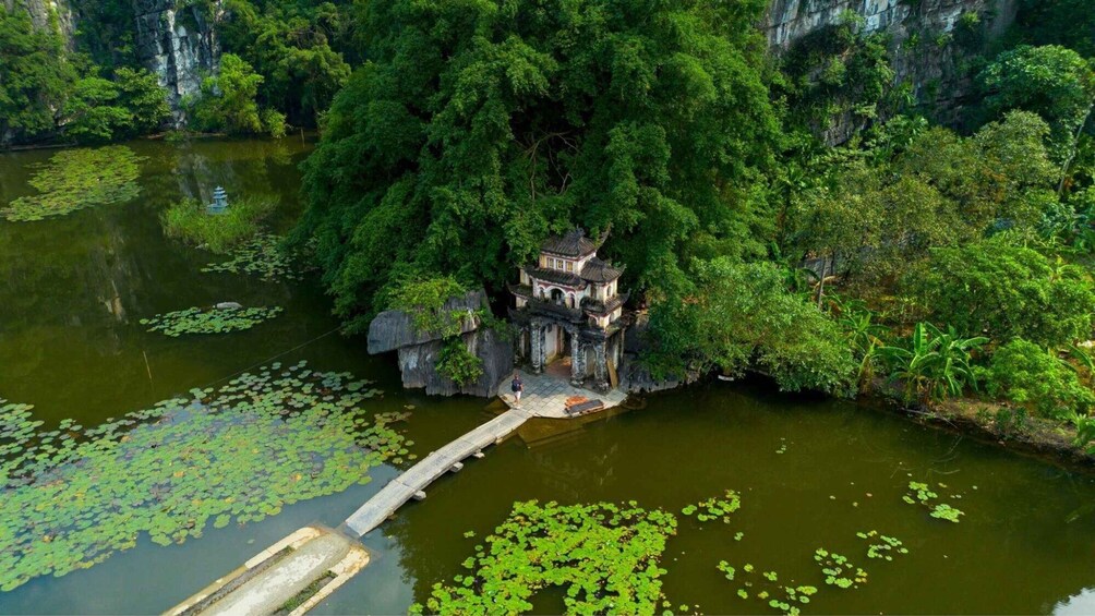 A traditional Chinese pavilion by a calm river, surrounded by lush greenery and lily pads. 3