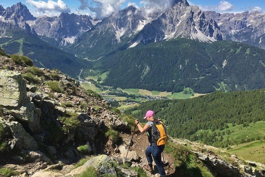 A hiker on a rocky trail with a mountainous landscape in the background. 3
