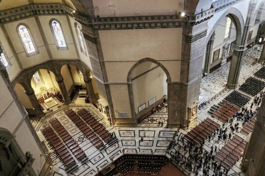 An interior view of a large cathedral with high ceilings, arched windows, and a central aisle. 4