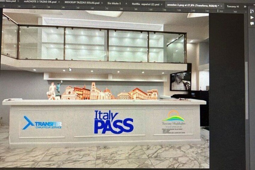 A reception desk with 'Italy PASS' branding, a 'TRANSIT' logo, and a 'Tuscany Hotels' sign. 2
