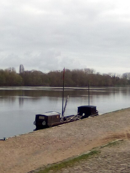 A calm river with boats docked on the shore. 4