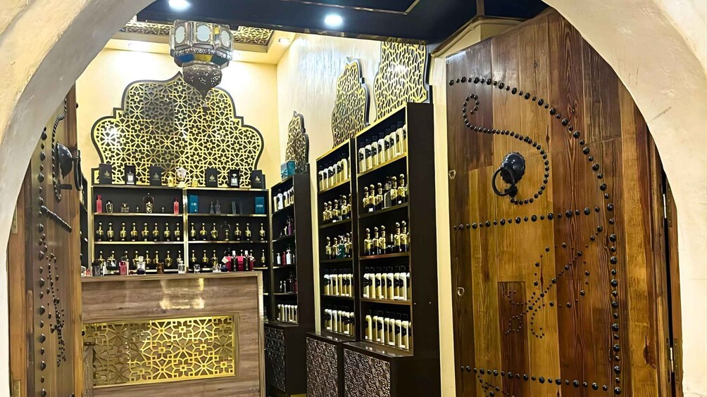 An interior with ornate wooden doors, shelves of perfume bottles, and decorative metalwork. 2