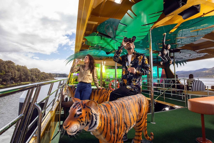 A boat with a green canopy, a person in a tiger costume, and a person drinking from a glass. 1
