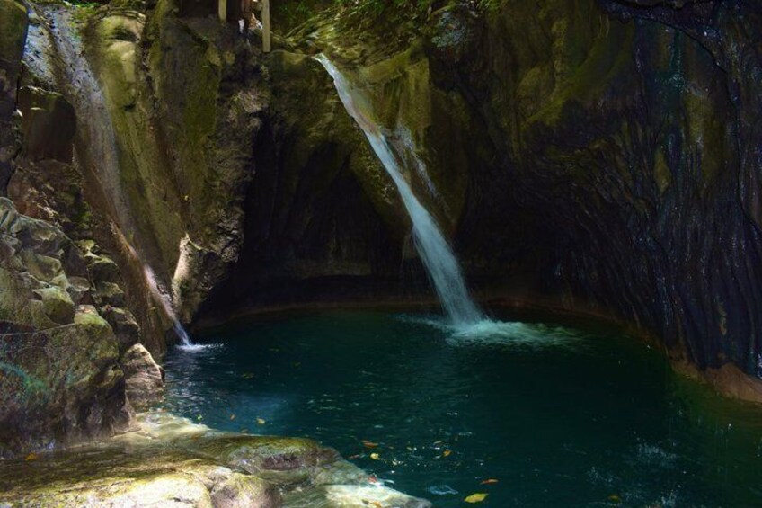 Ein Wasserfall in einer Höhle mit einem Becken am Fuße. 1