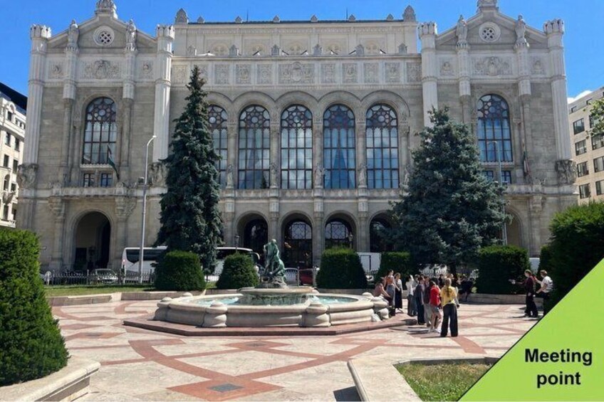 A historic building with large windows and a central fountain. 1