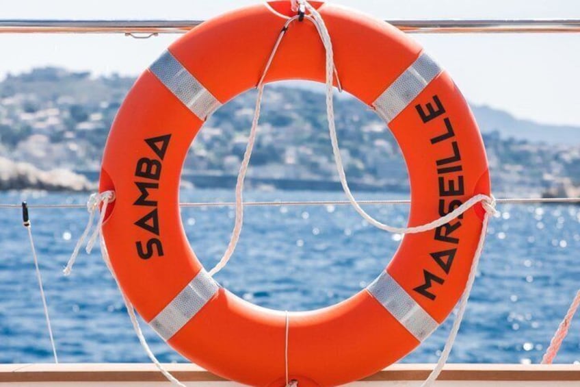 A lifebuoy with 'SAMBA' and 'MARSEILLE' written on it, hanging on a boat. 3