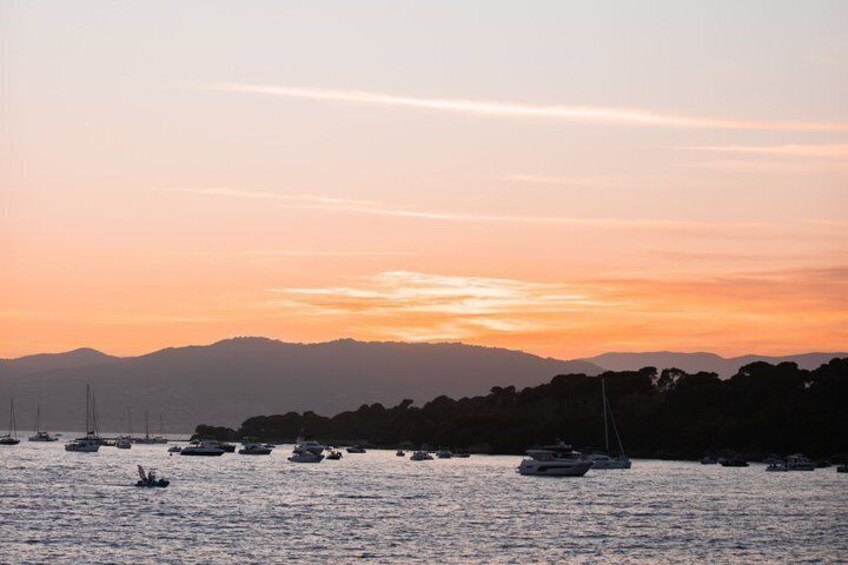 Un tramonto su un lago con barche e un paesaggio montuoso sullo sfondo. 5