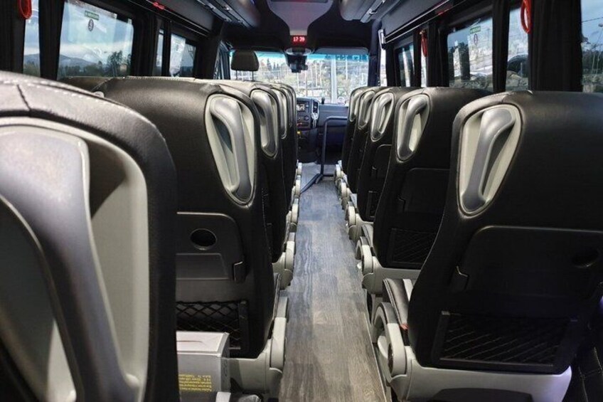 Insidan av en buss med rader av säten och en mittgång. 2