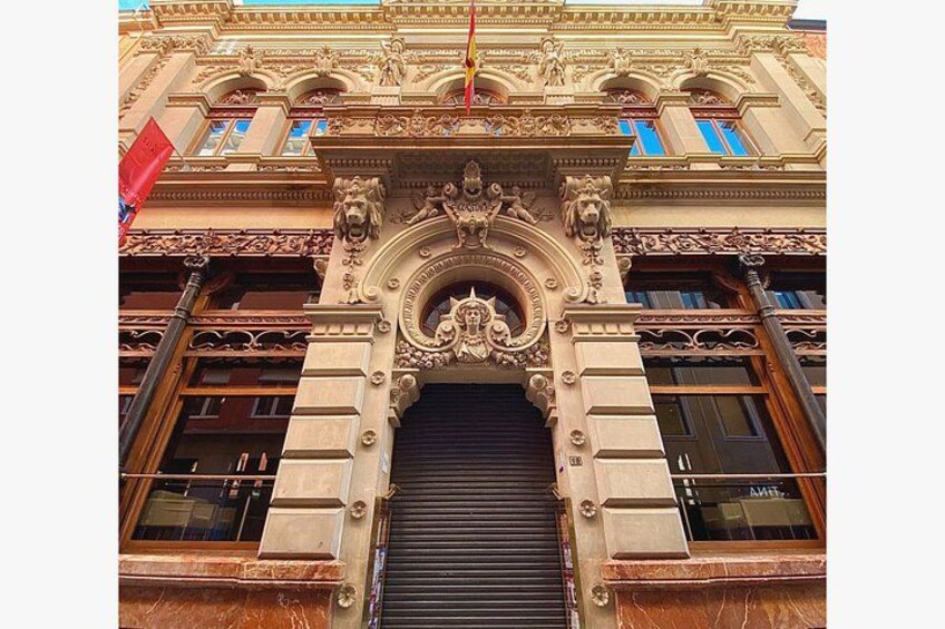 A building facade with ornate architectural details, including a central archway and decorative lion sculptures. 2