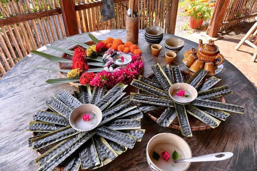 A table with a floral arrangement, a fan of leaves, and a teapot. 4