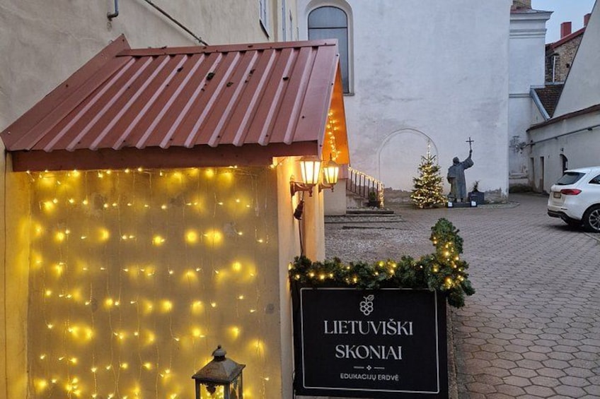 Un bâtiment sur lequel on peut lire l’inscription « Lietuvoski Skonai » et devant lequel se trouve un sapin de Noël. 5