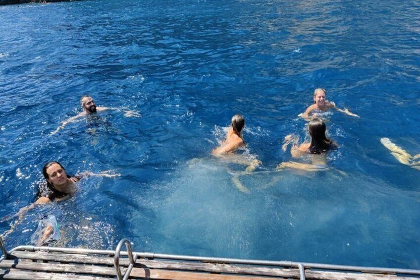 A group of people swimming in a clear blue pool. 5