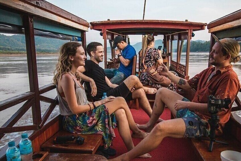 Un groupe de personnes est assis sur un bateau, et un appareil photo se trouve sur le pont. 5