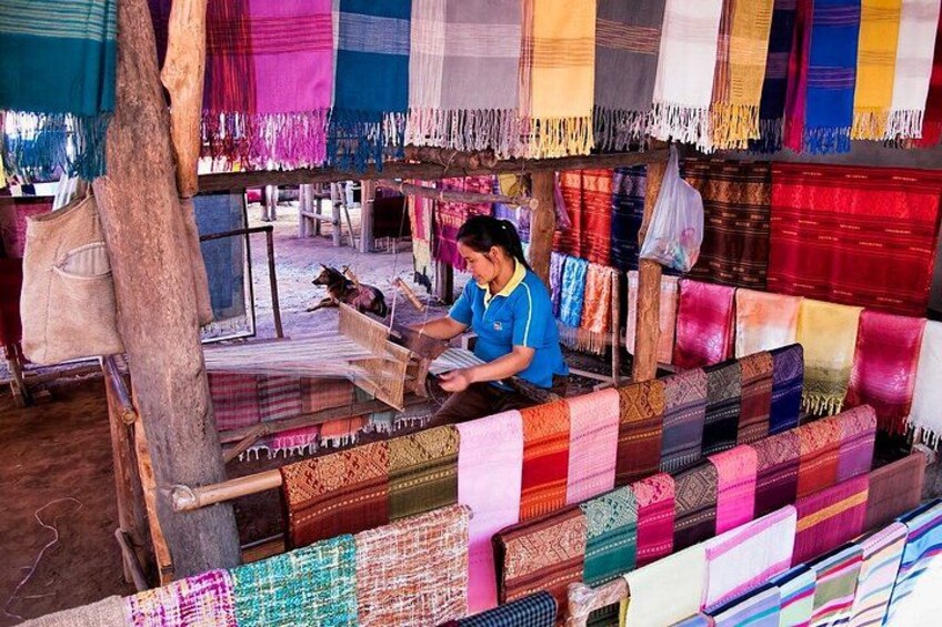 Une personne qui tisse des étoffes aux couleurs vives dans un cadre traditionnel. 4