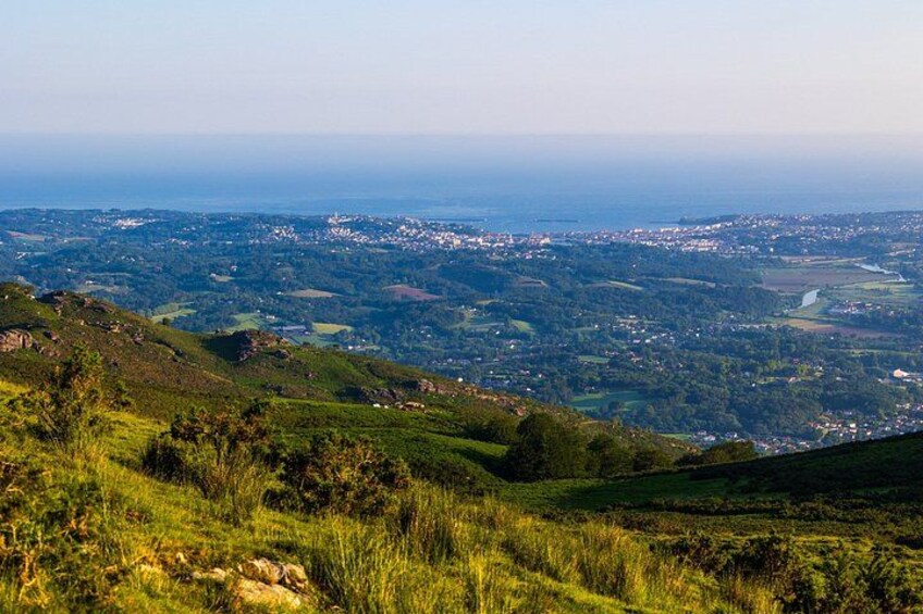 A hilly landscape with a view of a town and fields. 3