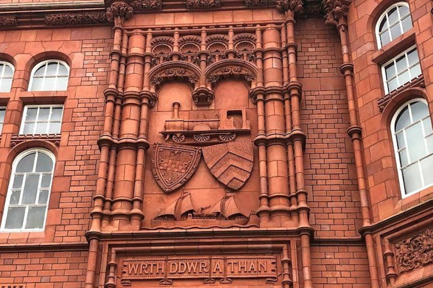 Un edificio de ladrillo rojo con elaboradas esculturas y un escudo. 1