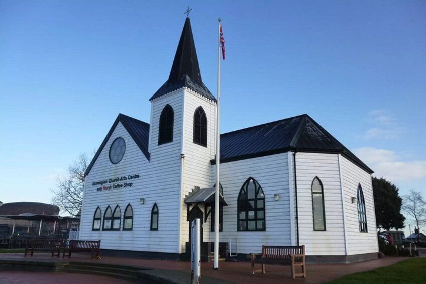 Una iglesia blanca con campanario y asta de banderas. 2