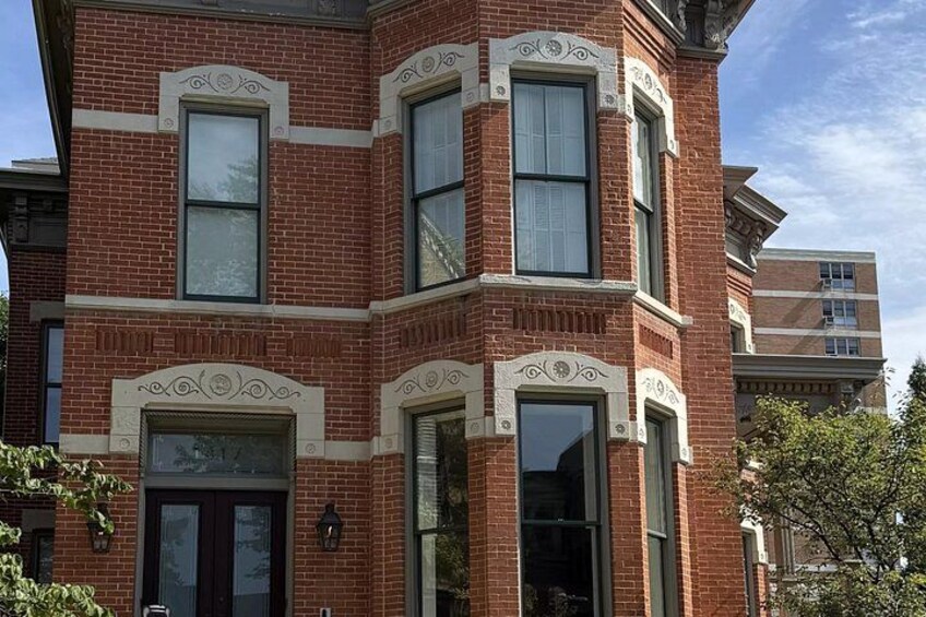 A red brick building with white trim, large windows, and decorative moldings. 1