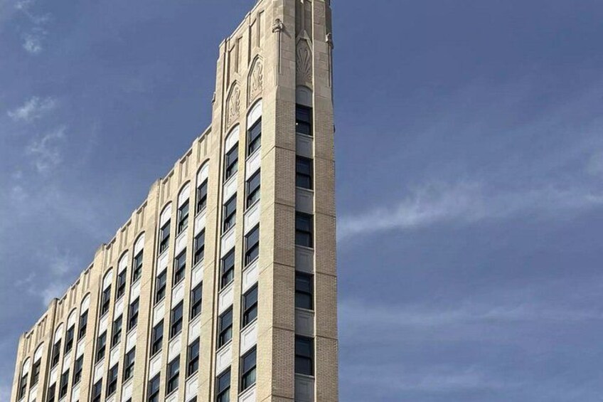 A tall building with a beige facade and multiple windows. 5