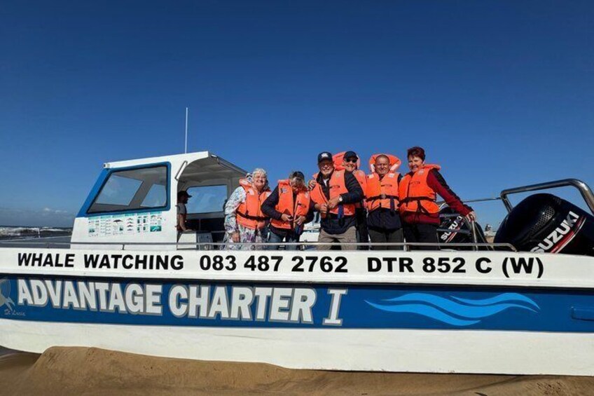 Ein Boot mit Personen, die Rettungswesten tragen, mit der Aufschrift 'WHALE WATCHING' und 'ADVANTAGE CHARTER I'. 5