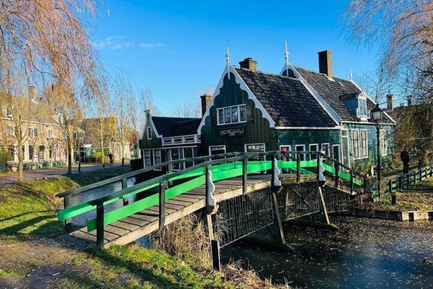 A green bridge over a canal with a building on the right. 2