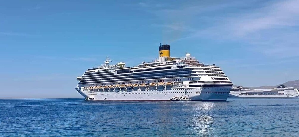 A large cruise ship with multiple decks and a prominent funnel, sailing in open waters. 5