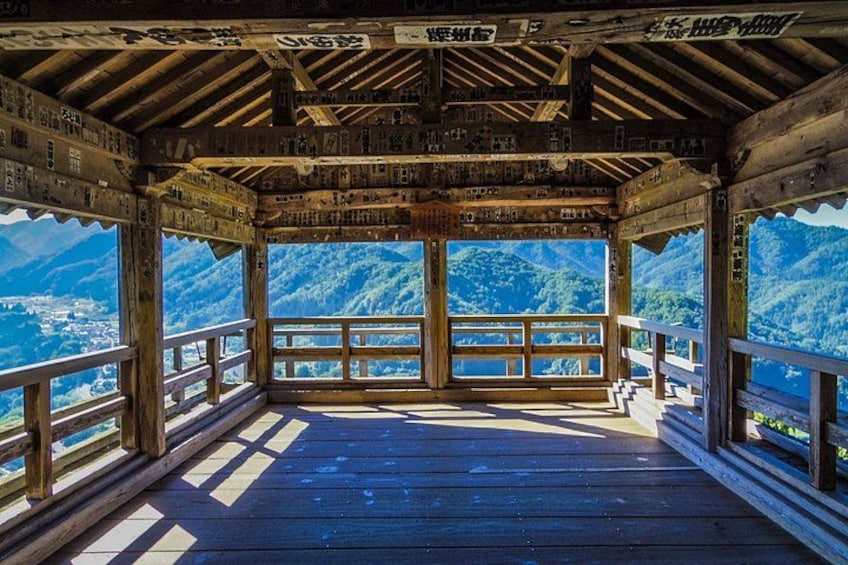 A wooden observation deck with a view of a mountainous landscape. 2