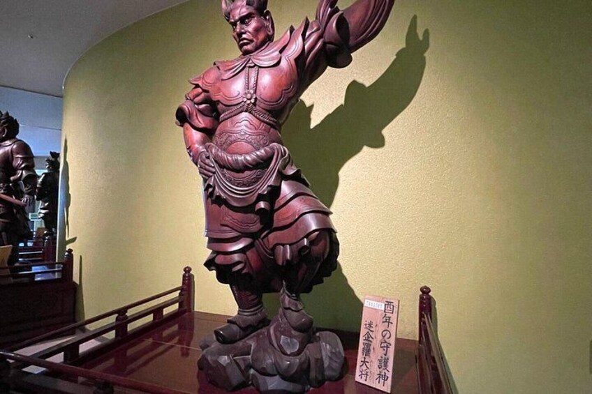 Una estatua de bronce de un guerrero con armadura sobre un pedestal, con un cartel delante. 5