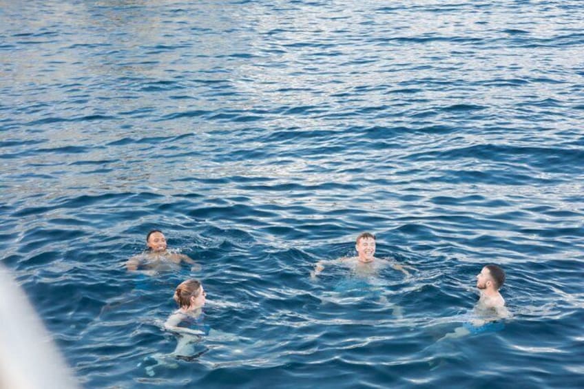 Four people swimming in a body of water. 1