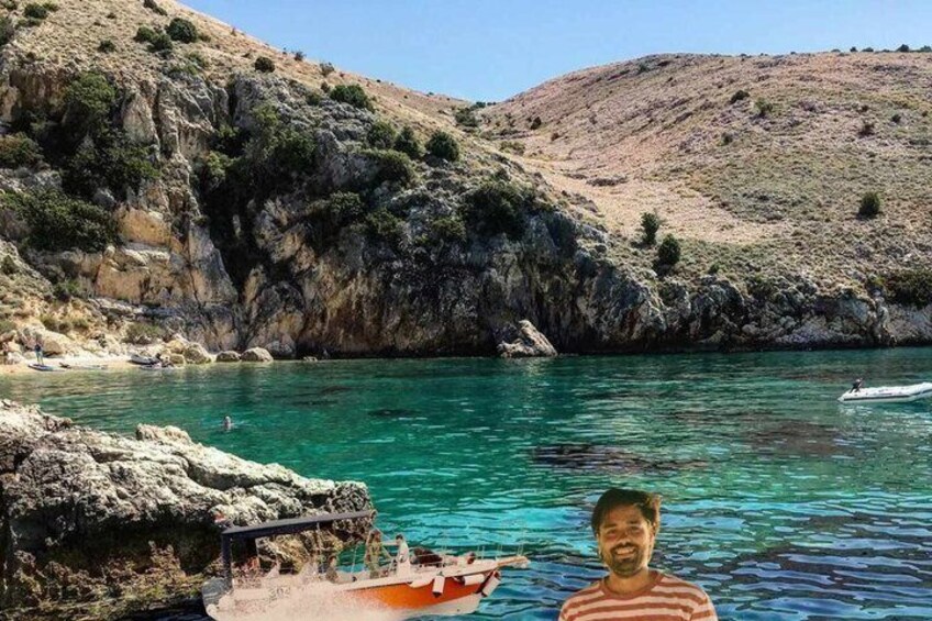 A coastal landscape with clear turquoise water, rocky cliffs, and a small boat. 1
