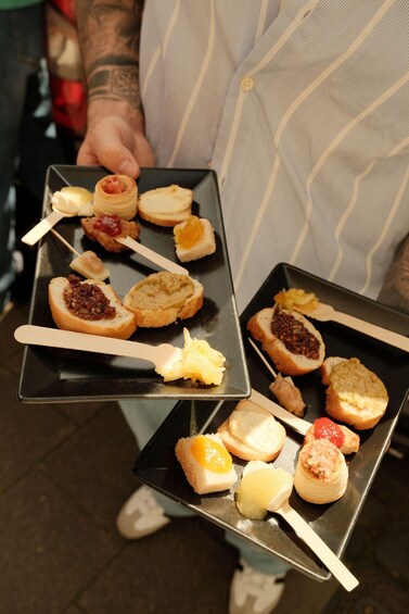 Two trays of assorted finger foods held by a person. 4