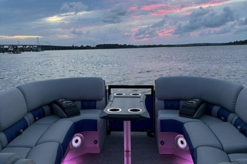 A boat with two cushioned seating areas and a central table. 4
