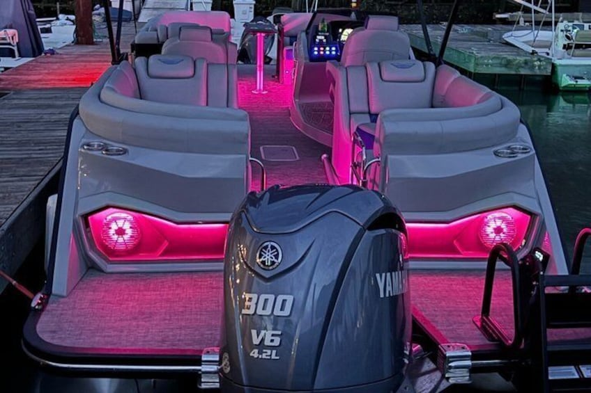 A speedboat with a Yamaha 300 V6 4.2L engine, equipped with red LED lighting, docked at a marina. 5