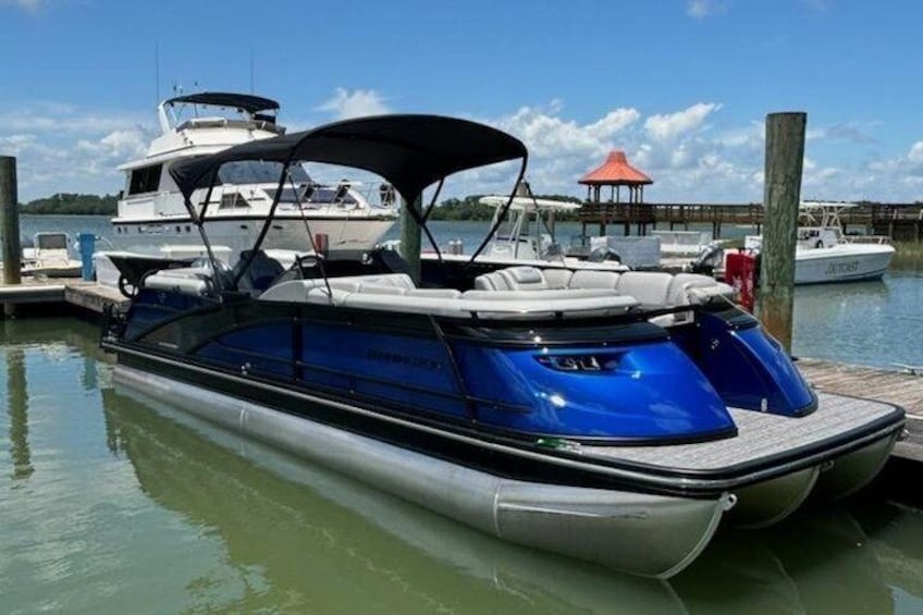 A blue and white boat docked at a pier with a gazebo in the background. 3