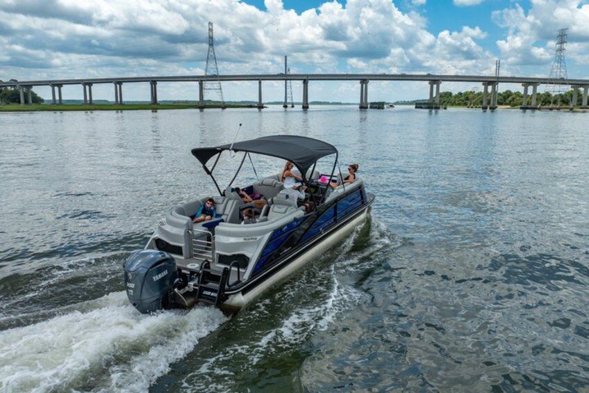 A motorboat with a canopy, moving on water with a bridge in the background. 5
