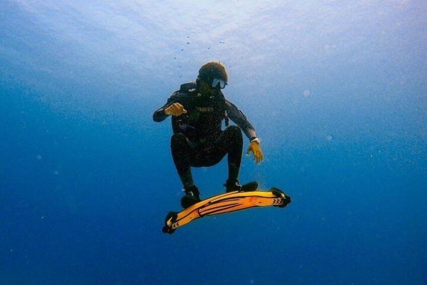 A person scuba diving with a yellow and black diving board. 5