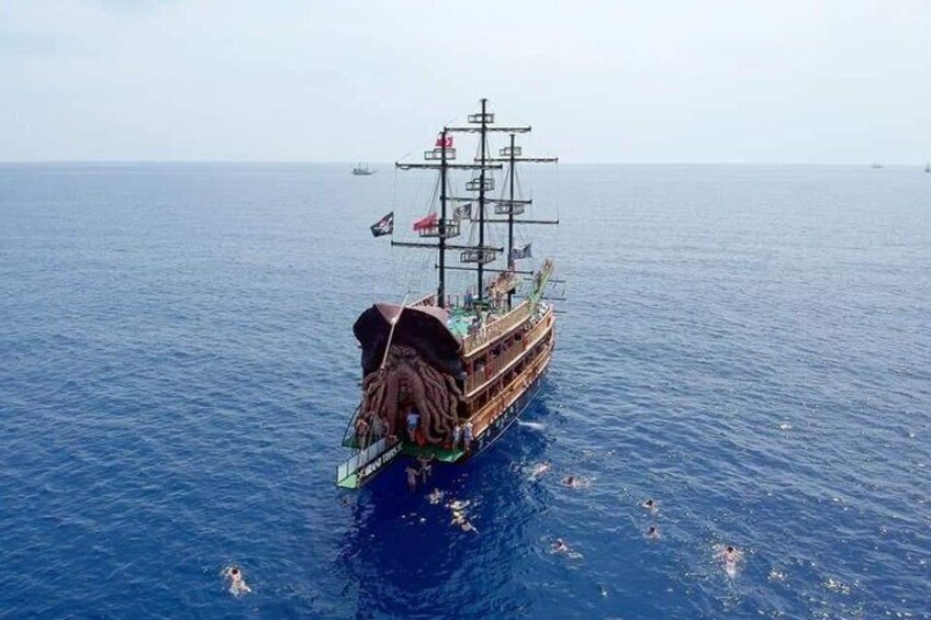 Een hoge zeilschip met meerdere masten en vlaggen, zeilt over een rustige zee. 5