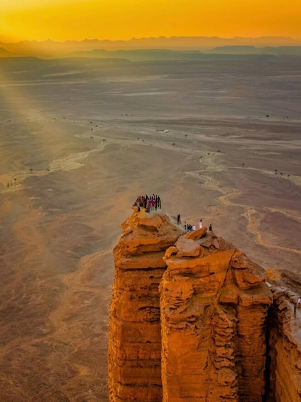 A group of people standing on a rock formation in a desert landscape. 3