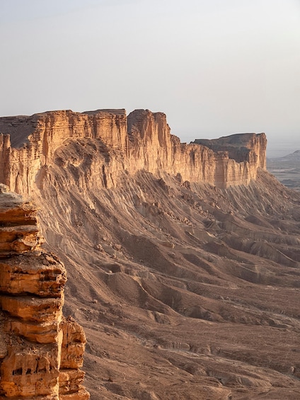 A vast desert landscape with prominent sandstone cliffs and layered rock formations. 4