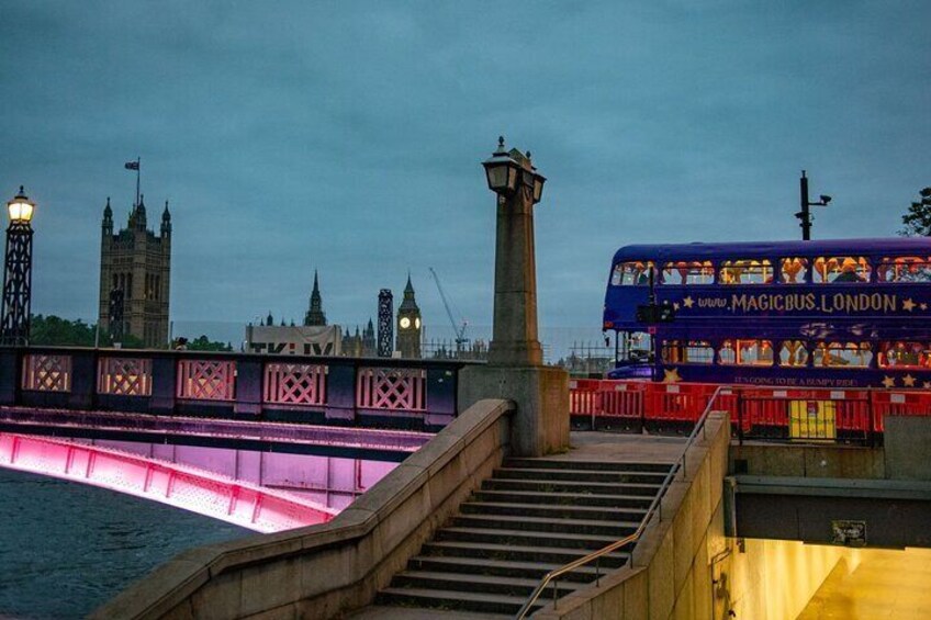 Ein Doppeldeckerbus mit der Aufschrift 'Magic Bus London' fährt über eine Brücke, im Hintergrund sind ein Turm und der Big Ben zu sehen. 2