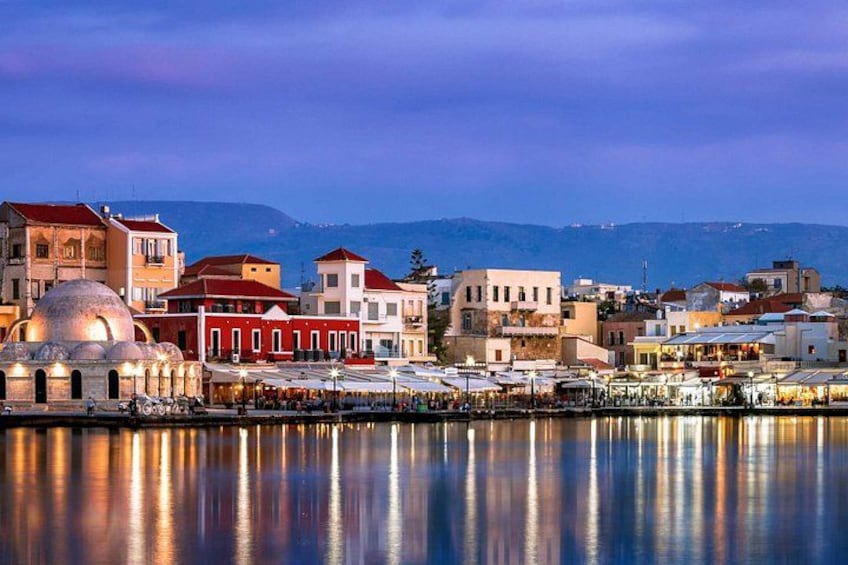 A waterfront cityscape with buildings, a dome structure, and a calm body of water reflecting the city lights. 5
