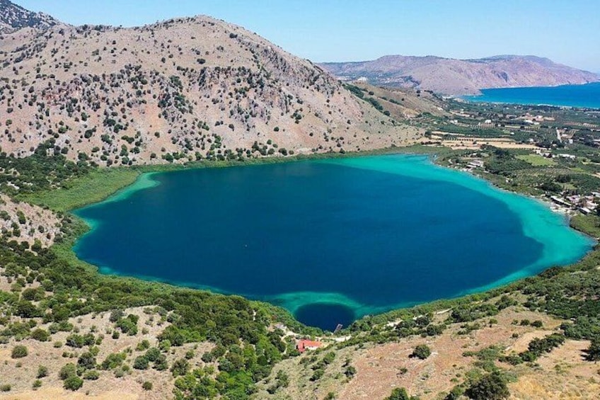 A large lake surrounded by hills and sparse vegetation. 1