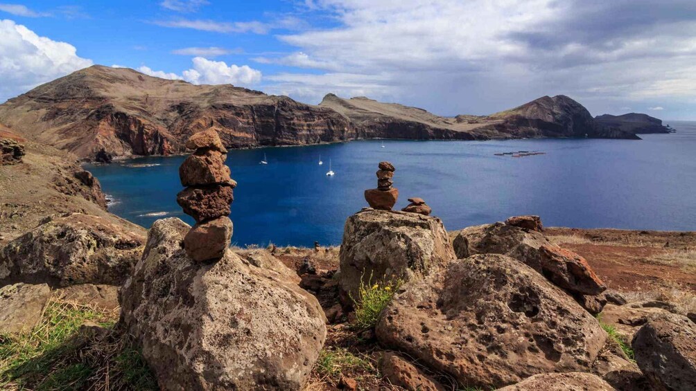 A coastal landscape with rocky formations and a clear blue sea. 1