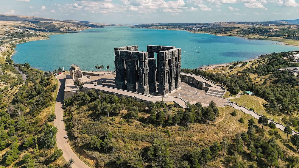 Un edificio grande y moderno con un diseño arquitectónico único, rodeado de un paisaje exuberante y una gran extensión de agua. 1
