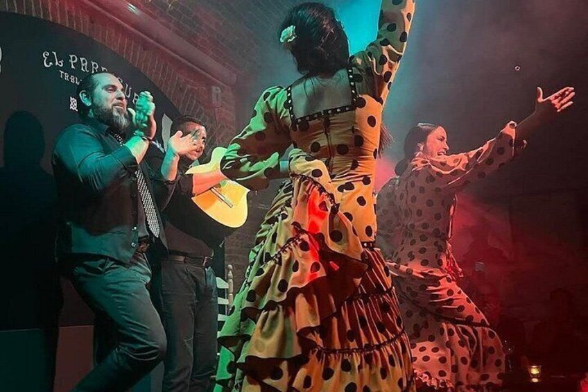 A person playing a guitar, another person dancing, and a third person clapping. 2