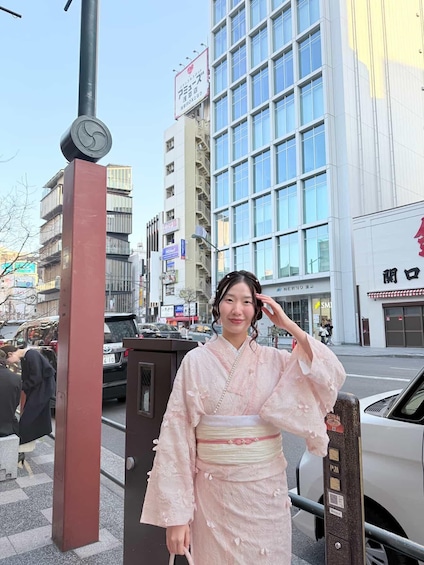 A person in traditional attire standing in front of a modern building with a clock on a pole. 2