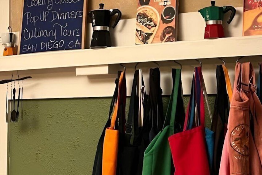 A kitchen with a chalkboard menu listing cooking classes, pop-up dinners, and culinary tours in San Diego, CA. 2