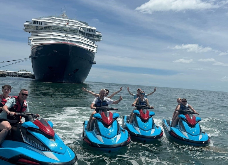 A group of people on jet skis near a large cruise ship. 1
