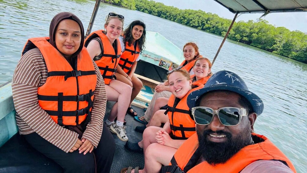 A group of people on a boat wearing life jackets. 5