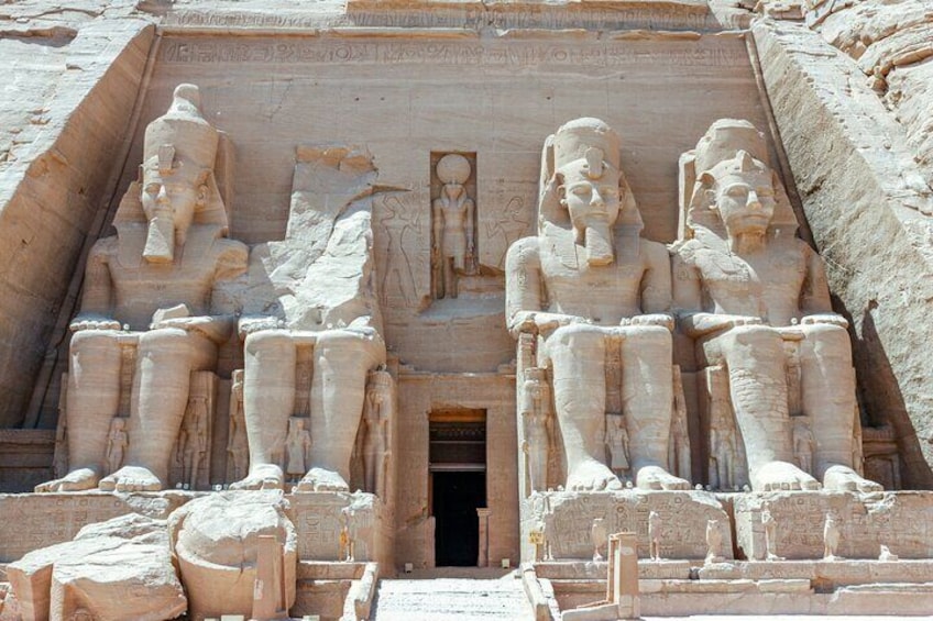 A large ancient Egyptian temple with colossal statues of pharaohs seated on steps. 3